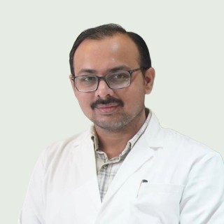 Portrait of Dr. Jaydipsinh B. Bhati wearing a white coat and glasses.